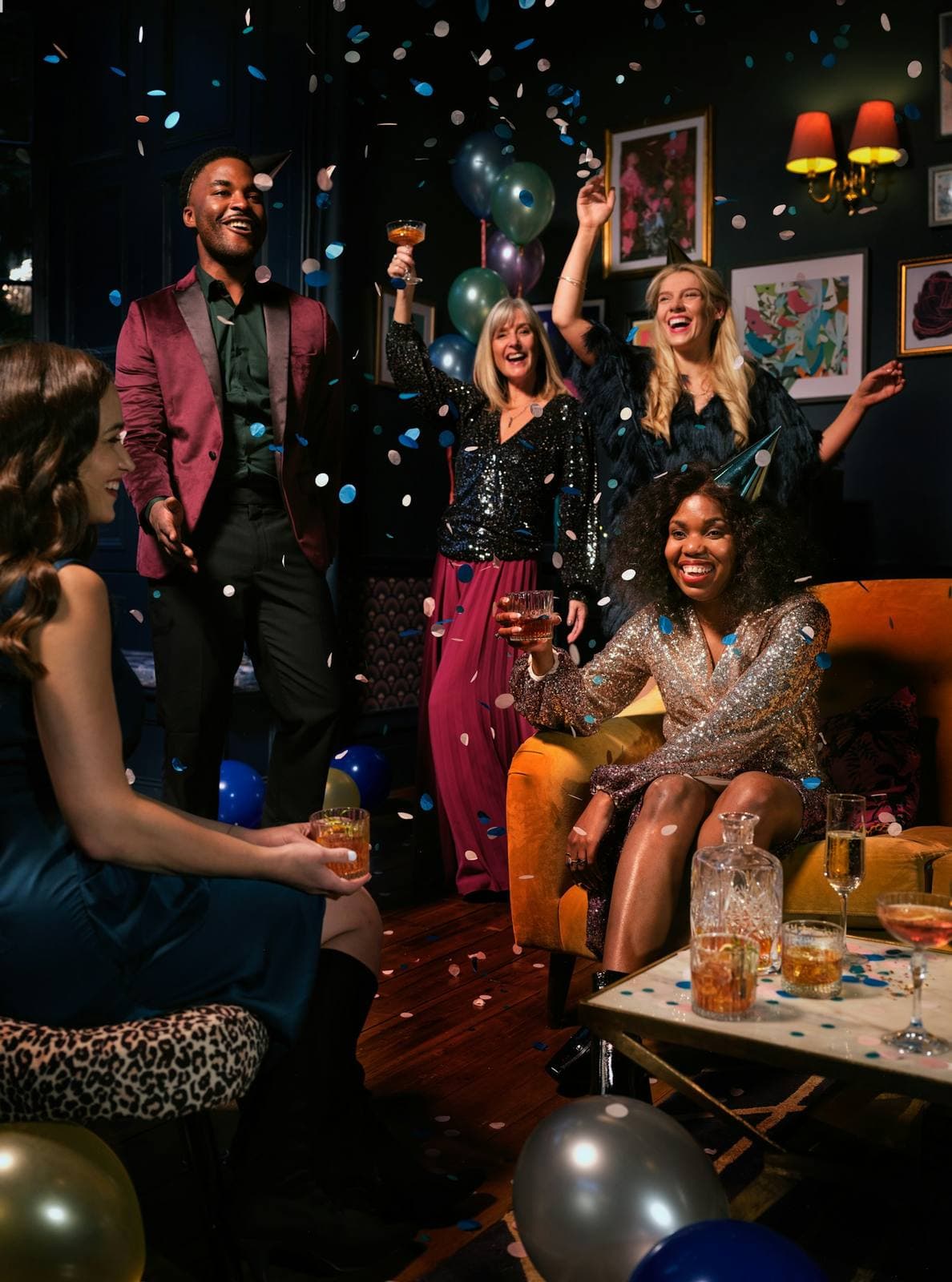 Feiernde Gäste mit Konfetti und Luftballons